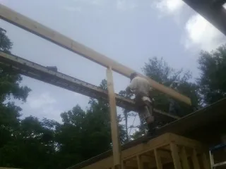 Carpenter setting a ridge beam over a new addition frame — Ice Dam Removal by Roofing Brothers in Schaefferstown