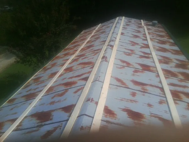 Rusted metal roof panels with new wood purlins before replacement — Storm Damage Roof Repair in Schaefferstown by Roofing Brothers