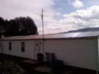 New metal roof on a single wide mobile home with a TV antenna in Schaefferstown