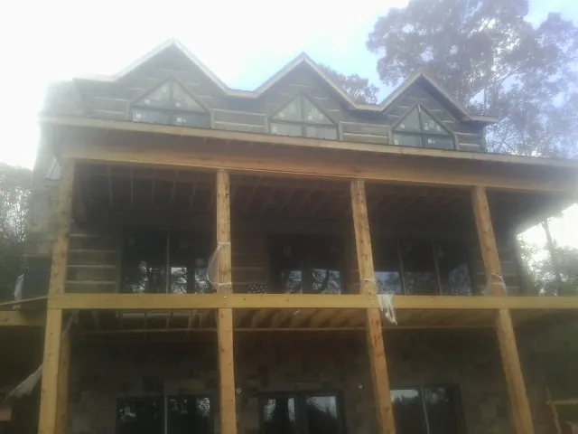 Dormers and porch framing on a large log home under construction — Roof Coating work by our crew in Schaefferstown