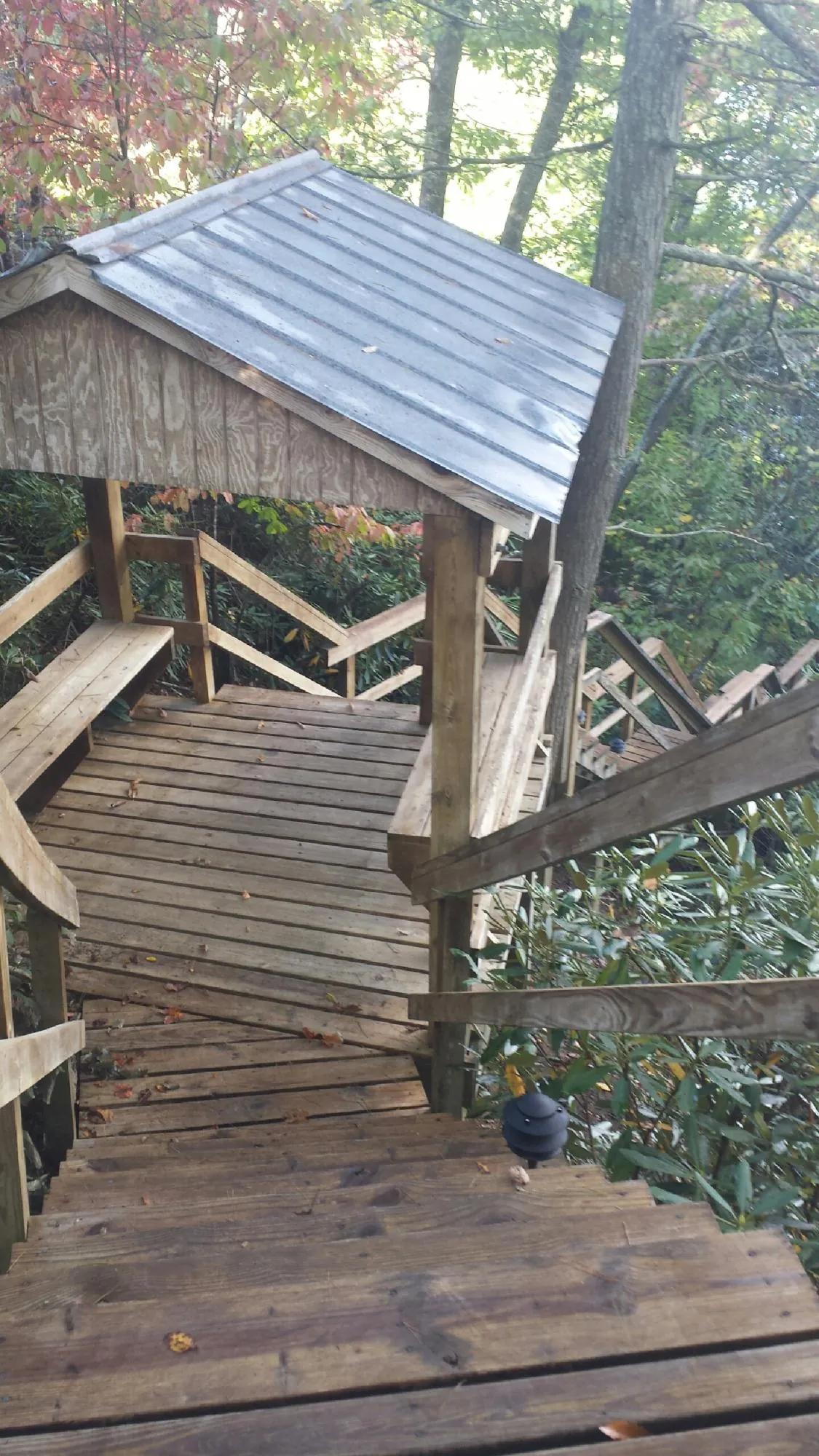 Metal roofed shelter over wooden steps on a wooded walkway — Skylight Repair & Installation work by our crew in Schaefferstown